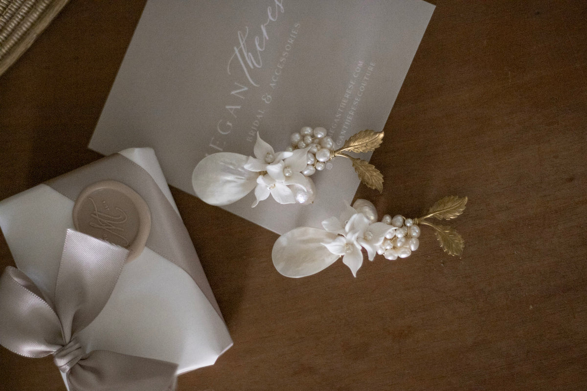 Handcrafted pearl and floral bridal earrings by Megan Therese, an Irish wedding jewellery designer, displayed on a table as part of the Try Before You Buy Bridal jewellery service.