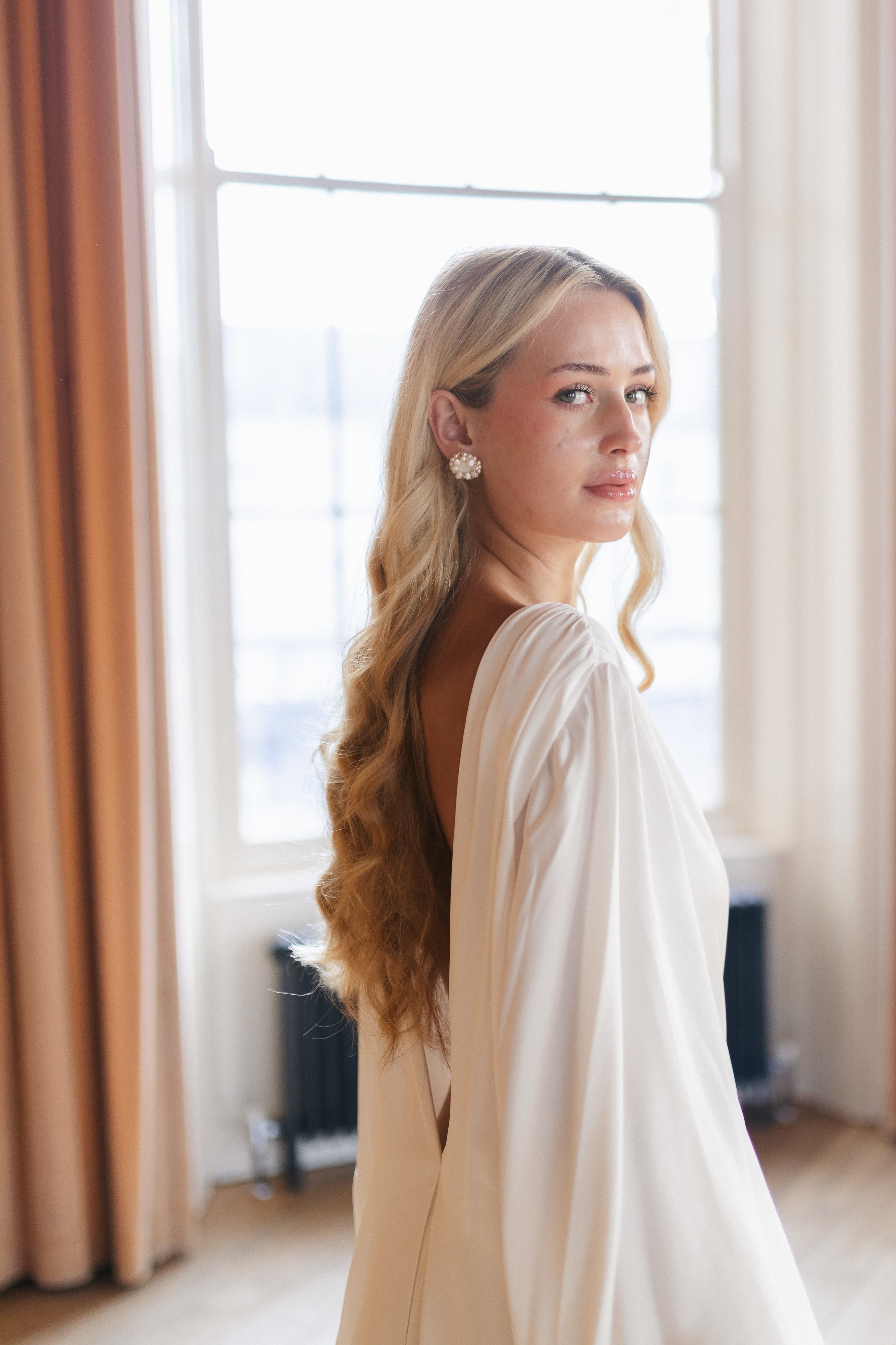 Statement pearl stud earring worn by bride with long hair.