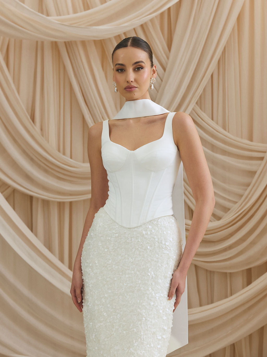 Bride wearing a wedding outfit with statement pearl earrings by megan therese